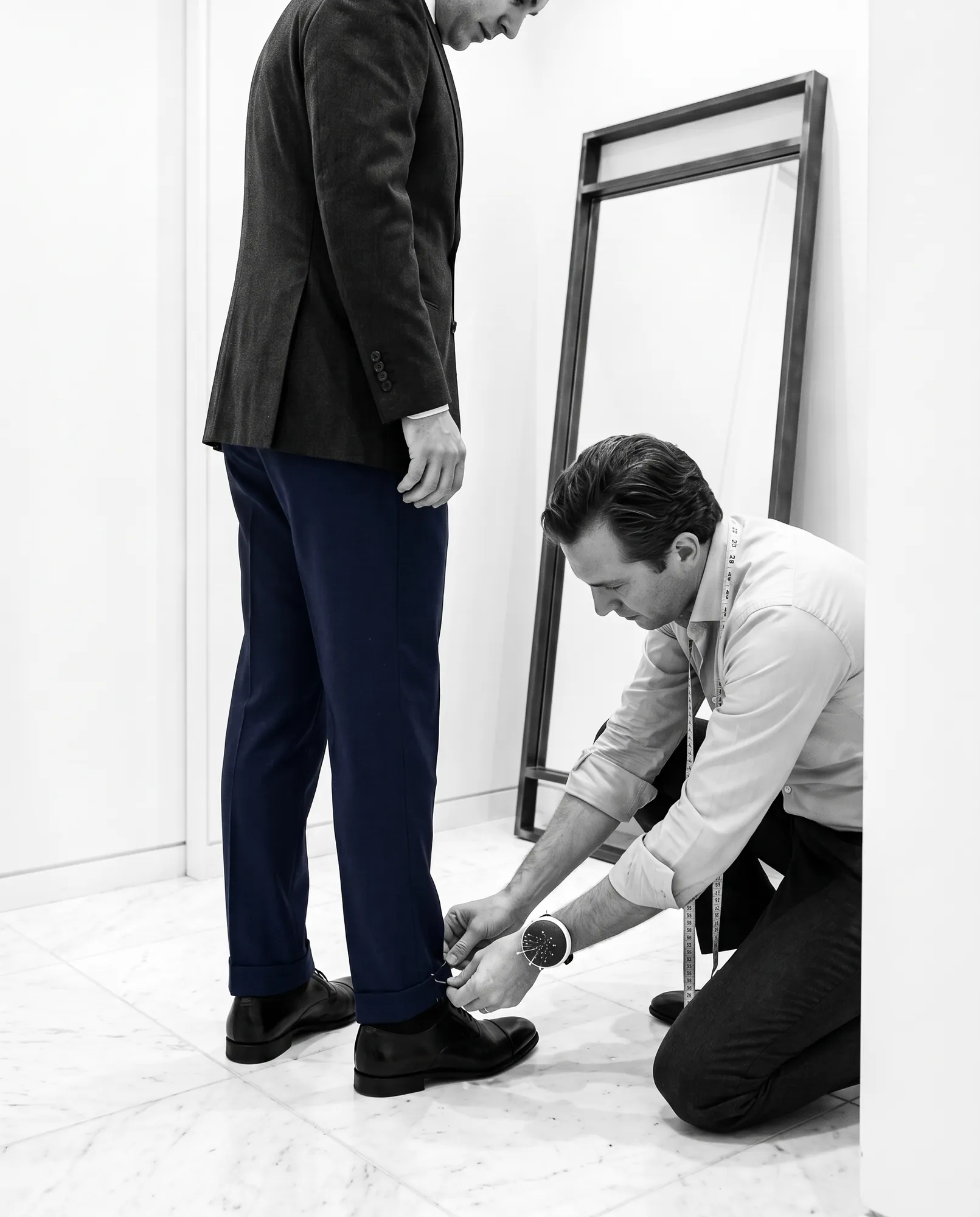 Tailor pinning a trouser hem